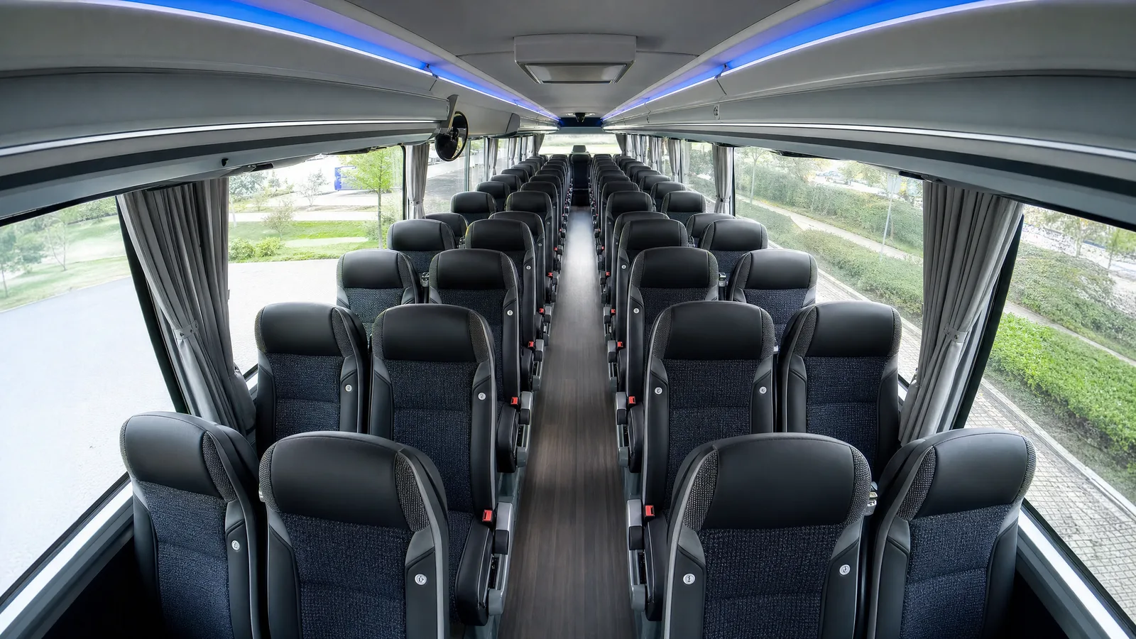 Onboard camera view down the aisle of empty passenger seats in a coach cabin