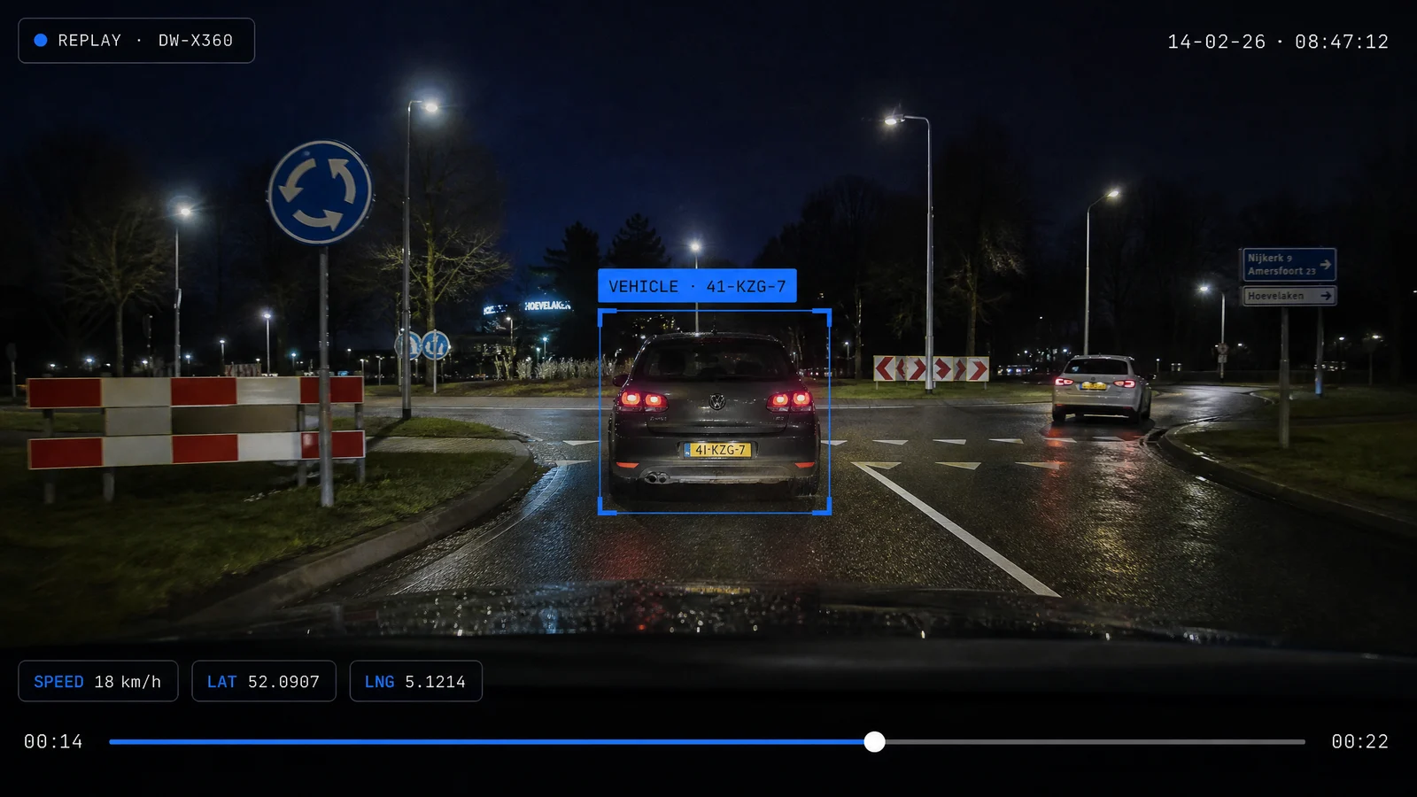 Dashcam-replay 's nachts: een gevolgde auto met kenteken in beeld bij een rotonde, met snelheid en gps-overlay.